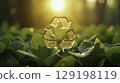 Golden glitter recycling symbol above green leaves in sunlight 129198119