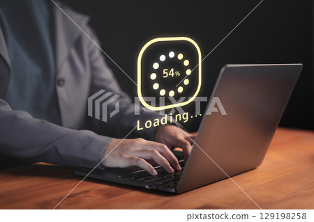Female employee types on a laptop with a floating Loading... progress bar, representing data processing or digital wait time in a modern tech environment, anticipation of technology responding. Female employee types on a laptop with a floating Loading... progress bar, representing data processing or digital wait time in a modern tech environment, anticipation of technology responding. 129198258