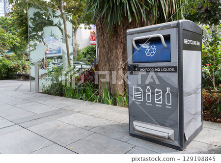 Singapore, Singapore - May 01, 2025: Recycling bin on Orchard Road with greenery backdrop Singapore, Singapore - May 01, 2025: Recycling bin on Orchard Road with greenery backdrop 129198845
