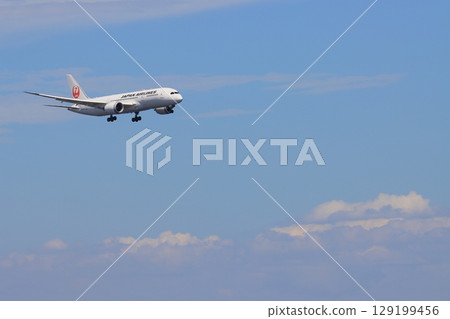 一架客機在藍天背景下降落,一架日航飛機正在進場 一架客機在藍天背景下降落,一架日航飛機正在進場 129199456