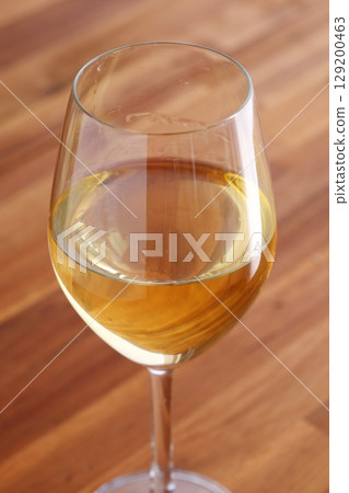 White wine glass - Golden white wine poured into a wine glass 129200463
