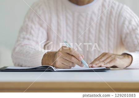老人的手拿著一支筆 老人的手拿著一支筆 129201083