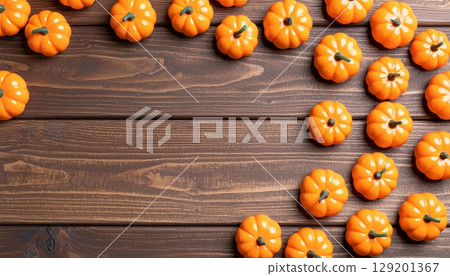 Bright orange pumpkins, a festive symbol of the fall harvest, decorate a rustic wooden background for Halloween Bright orange pumpkins, a festive symbol of the fall harvest, decorate a rustic wooden background for Halloween 129201367