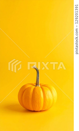 An isolated orange pumpkin on a wooden table, perfect for a fall harvest or Halloween theme An isolated orange pumpkin on a wooden table, perfect for a fall harvest or Halloween theme 129201391