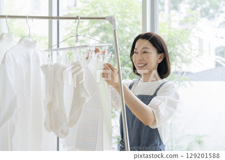 一位 50 多歲的女士正在晾衣服 一位 50 多歲的女士正在晾衣服 129201588