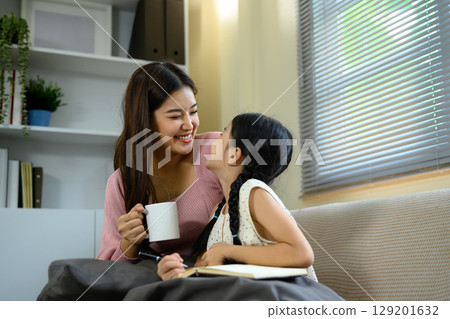 Happy mom and child sharing conversation in a bright living room 129201632