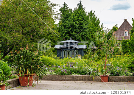 The Botanical Garden of Augsburg in Germany with garden pathes and topiary boxwood bushes on green meadows The Botanical Garden of Augsburg in Germany with garden pathes and topiary boxwood bushes on green meadows 129201874
