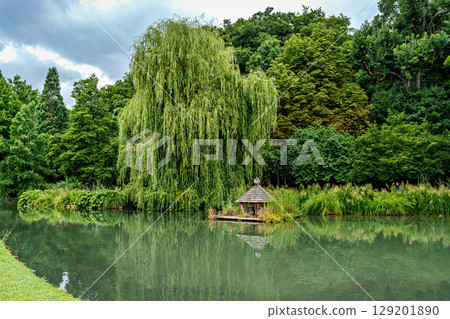 The Botanical Garden of Augsburg in Germany with garden pathes and topiary boxwood bushes on green meadows 129201890