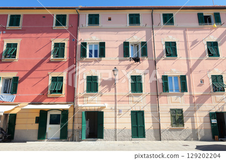 Old street in Italian countryside near sea. Traditional building. Sun day. Entrance, window to house. Nature and sky. 129202204