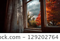 Beautiful autumn foliage seen through a house window on a cloudy day. 129202764