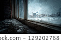 Raindrops on an old window pane, looking out at a snowy urban landscape on a gloomy winter day. 129202768