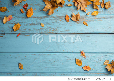 Scattered autumn leaves, frames and picture frames on a wooden table 129203004