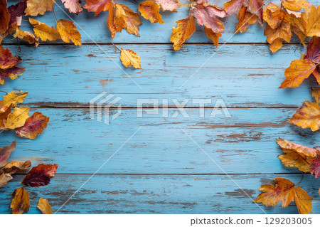 Scattered autumn leaves, frames and picture frames on a wooden table 129203005