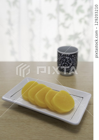 Pickled radish and Japanese tea on the table 129203210