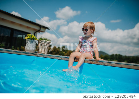 Little girl enjoying summer by the pool 129203484