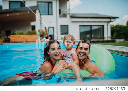 Happy family enjoying summer at pool 129203485