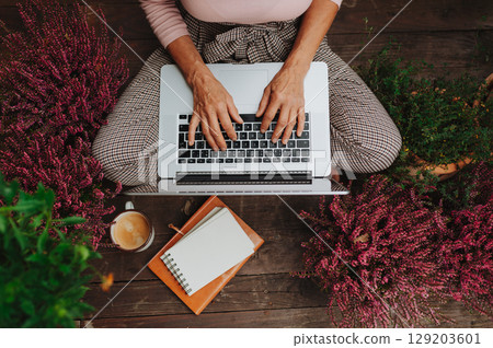 Top view of woman sitting on floor and working from homeoffice. 129203601