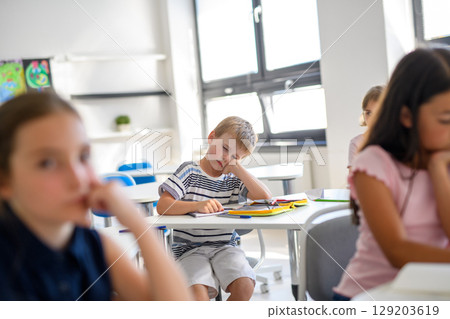 Tired schoolboy struggling to stay awake during class 129203619