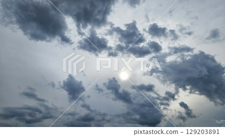 Dark blue clouds and sunlight in the sky Dark blue clouds and sunlight in the sky 129203891