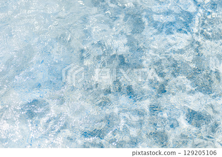 The clear blue water displays a mesmerizing texture as sunlight dances on its surface. Gentle ripples create an inviting atmosphere for relaxation and enjoyment The clear blue water displays a mesmerizing texture as sunlight dances on its surface. Gentle ripples create an inviting atmosphere for relaxation and enjoyment 129205106