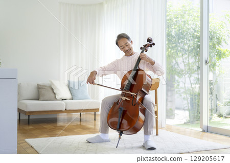 A man in his 60s playing the cello 129205617
