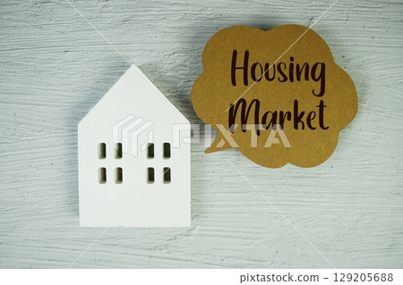 Housing Market text message with white house model on concrete background 129205688