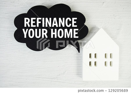 Refinance Your Home text message on speech bubble with house model on concrete background Refinance Your Home text message on speech bubble with house model on concrete background 129205689