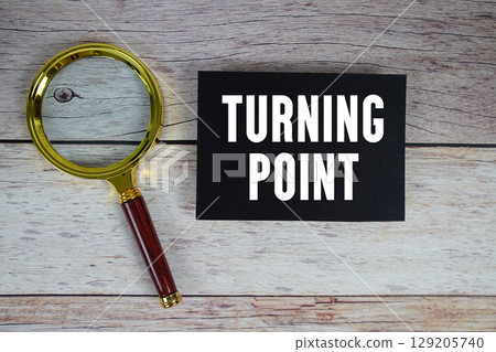 Turning Point text written on paper with magnifying glass 129205740