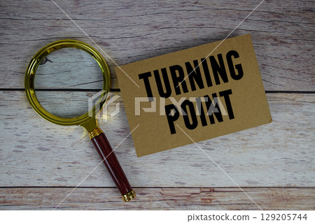 Turning Point text written on paper with magnifying glass 129205744