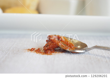 Spoon with red sauce spilled table cloth Spoon with red sauce spilled table cloth 129206201