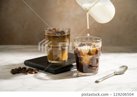 Glass with iced latte, refreshing energy coffee drinks Glass with iced latte, refreshing energy coffee drinks 129206504