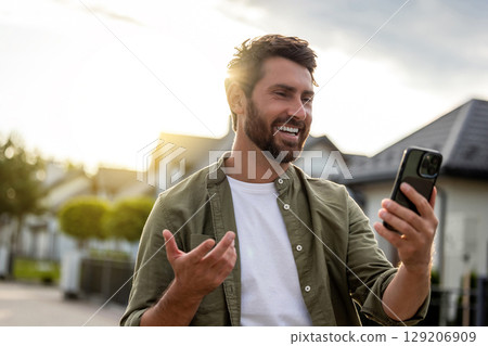 Smiling confident man talking via video and asking about the route Smiling confident man talking via video and asking about the route 129206909