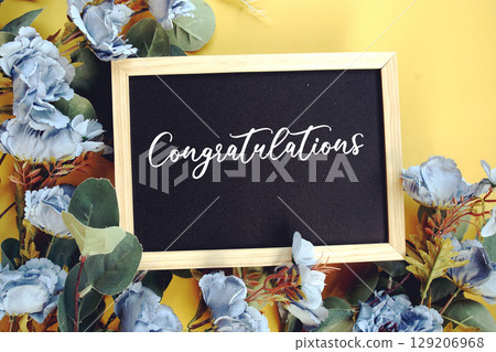 Congratulations text with flowers decoration on yellow background Congratulations text with flowers decoration on yellow background 129206968