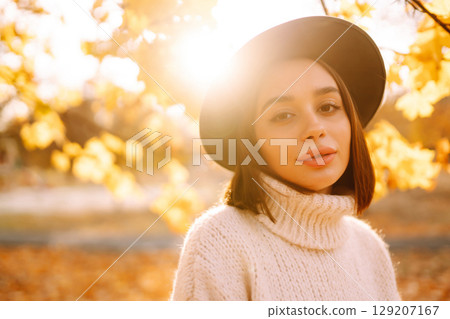 Sunny lifestyle portrait of young stylish woman walking on park, wearing cute trendy hat. Fashion concept. Sunny lifestyle portrait of young stylish woman walking on park, wearing cute trendy hat. Fashion concept. 129207167