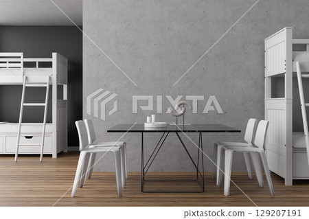 A contemporary hostel interior features wooden flooring, white bunk beds, and a sleek black dining table surrounded by chairs. The space blends comfort with practicality for travelers 129207191