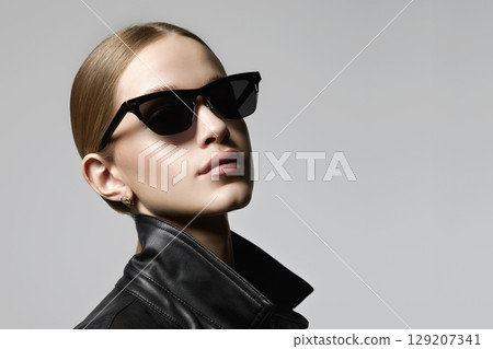 pretty blond girl in black glasses and leather coat pretty blond girl in black glasses and leather coat 129207341