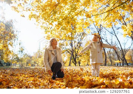 Young Mother and daughter walking in the park and enjoying the beautiful autumn nature. Walk, family 129207761