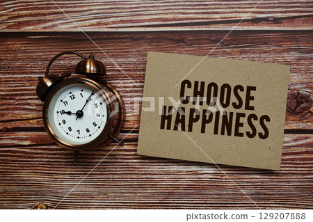 Choose Happiness text with alarm clock on wooden background 129207888