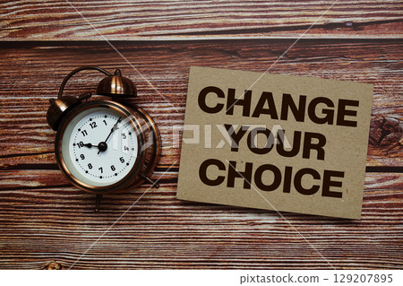 Change Your Choice text with alarm clock on wooden background Change Your Choice text with alarm clock on wooden background 129207895