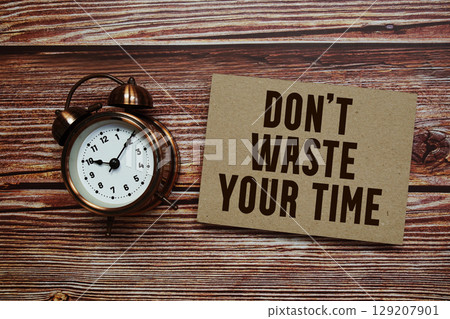 Don't Waste Your Time text with alarm clock on wooden background 129207901