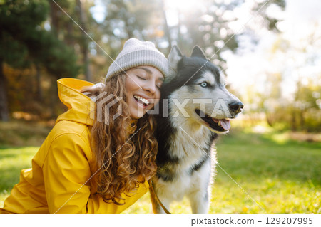 Happy female posing outdoors with her dog. Concept of friendship, vacation, walk. Happy female posing outdoors with her dog. Concept of friendship, vacation, walk. 129207995
