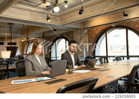 Colleagues working in the office and looking busy and involved 129208005