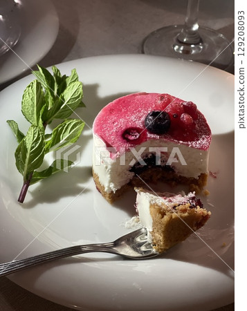 Delicious Berry Cheesecake Slice on Plate with Fork Delicious Berry Cheesecake Slice on Plate with Fork 129208093