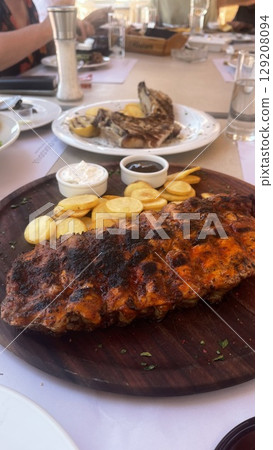 Grilled Ribs and Potatoes on Wooden Platter Grilled Ribs and Potatoes on Wooden Platter 129208094