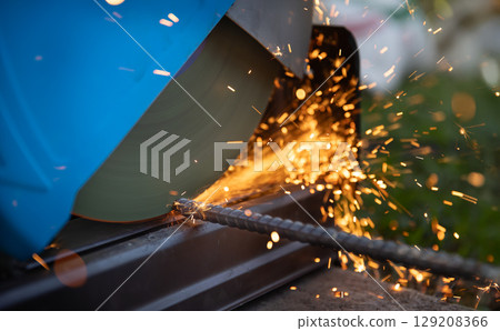Worker cutting deformed steel bar in construction site. Worker cutting deformed steel bar in construction site. 129208366