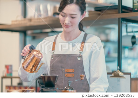Part-time female employee and male customer at a fashionable cafe Part-time female employee and male customer at a fashionable cafe 129208553