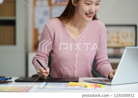 Female coder or developer working using a computer display and smartphone in problem solving at workplace. Female coder or developer working using a computer display and smartphone in problem solving at workplace. 129208932