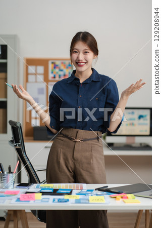 lifestyle of office workers, Woman successful standing front at the desk, looking to camera. 129208944