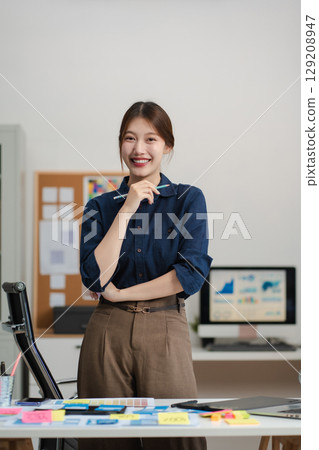 lifestyle of office workers, Woman successful standing front at the desk, looking to camera. 129208947