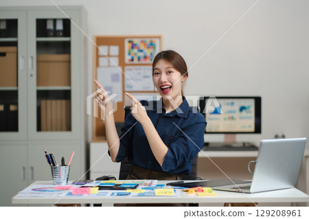 lifestyle of office workers, Woman successful standing front at the desk, looking to camera. 129208961